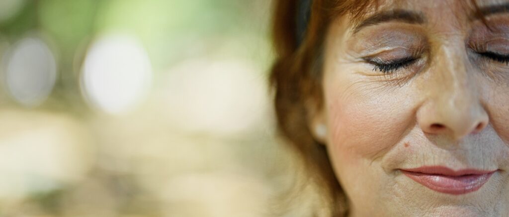 woman in the park with eyes closed