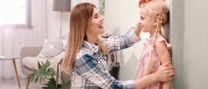 Mother measuring daughter's height