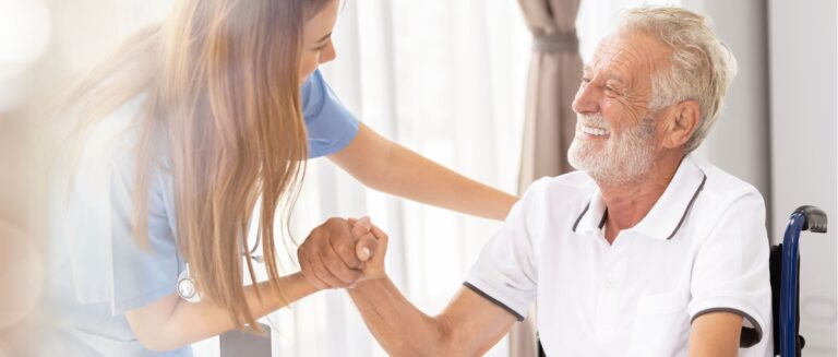 Caretaker tending to a senior man in a wheelchair.