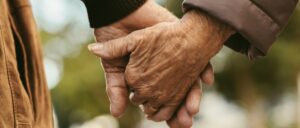 Elderly couple holding hands and walking