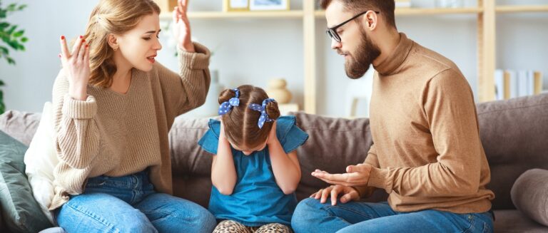 Stressed child covering ears while parents argue on the couch, illustrating emotional distress and family conflict.