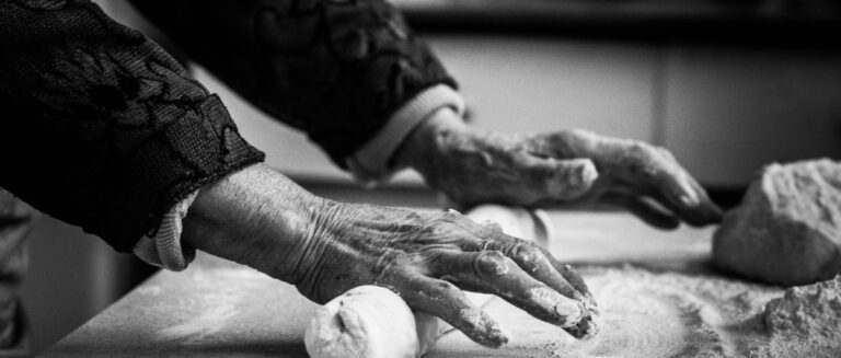 Hands of an old woman at work with the dough