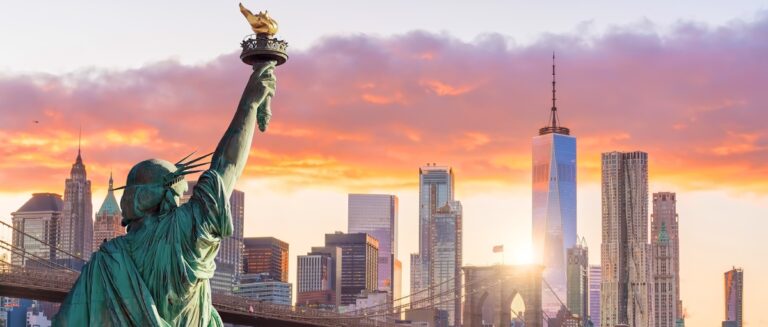 Statue Liberty and New York city skyline at sunset